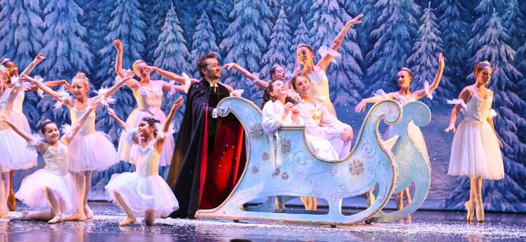 Nutcracker dancers in a sleigh on stage